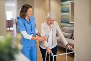 Older adult sharing a meal with a caregiver in a bright assisted living dining room.